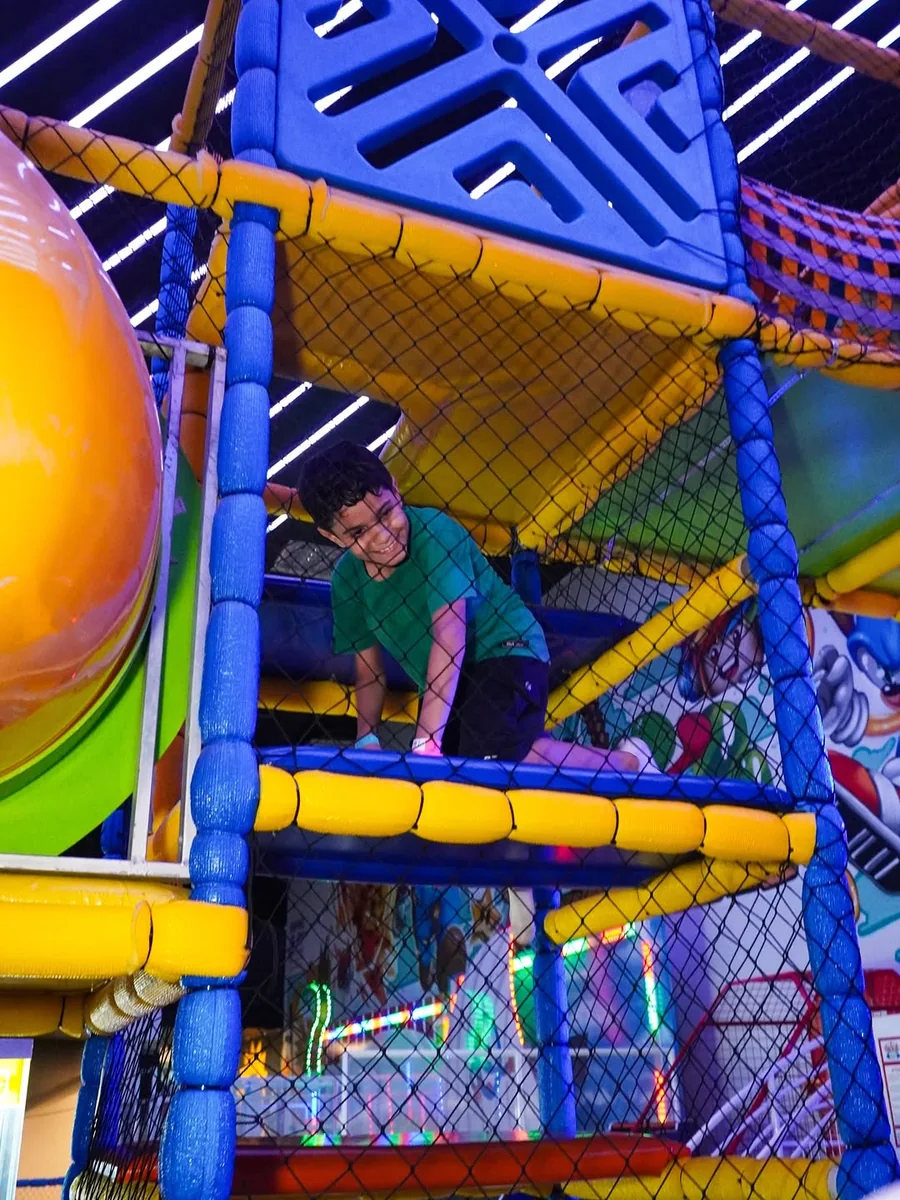 Torre de escalada com toboágua e estrutura de tubos coloridos