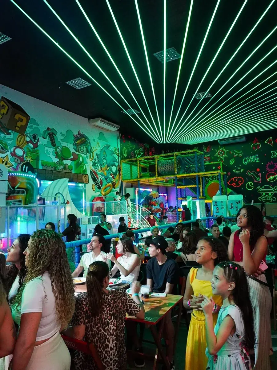 Salão temático com teto em raios de neon preparado para festas